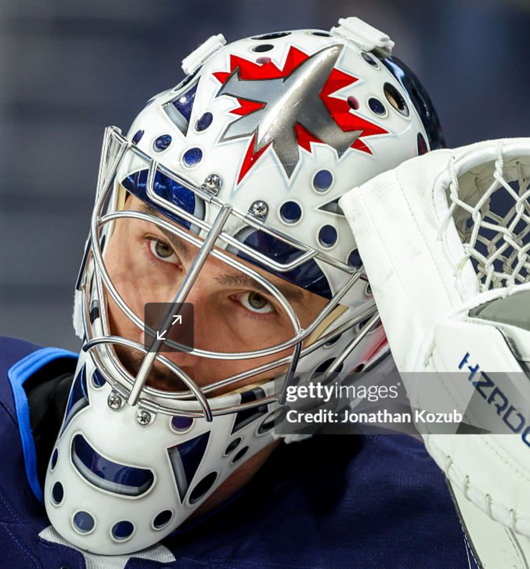 Goalie wearing the mask in a reference photo for Connor Hellebuyck Signed Goalie Mask 2025 26 Winnipeg Vintage Signature Edition. Goalie Mask Collector.